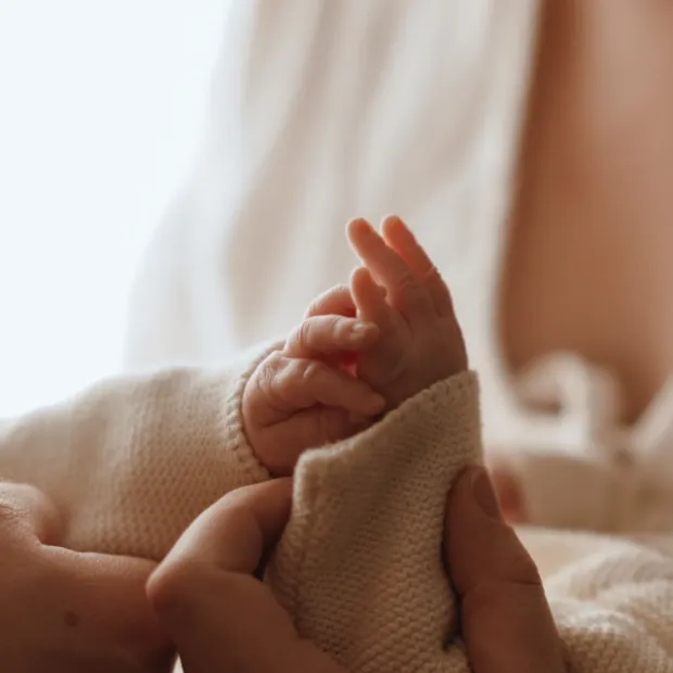 Petite main de bébé dans les mains de ses parents
